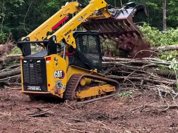 Land clearing in Statesboro GA with a compact track loader clearing brush from red dirt